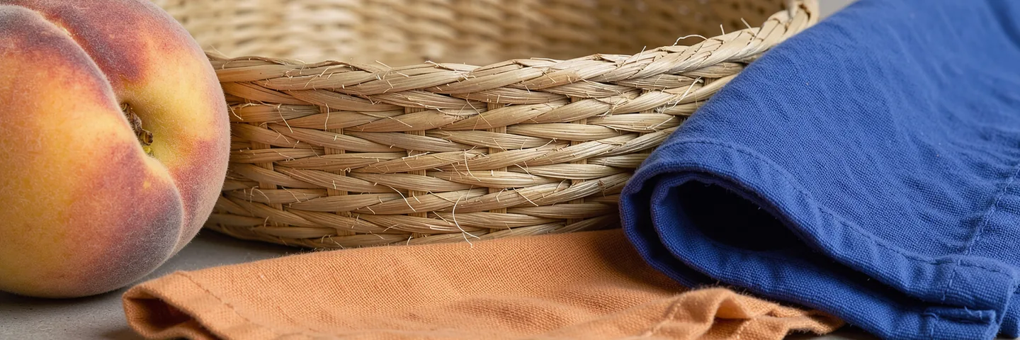 Velvety peach peel, a woven basket edge and the soft weave of royal-blue cotton in side light